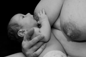 Mãe amamentando seu bebê, reforçando a importância da alimentação balanceada no pós-parto.