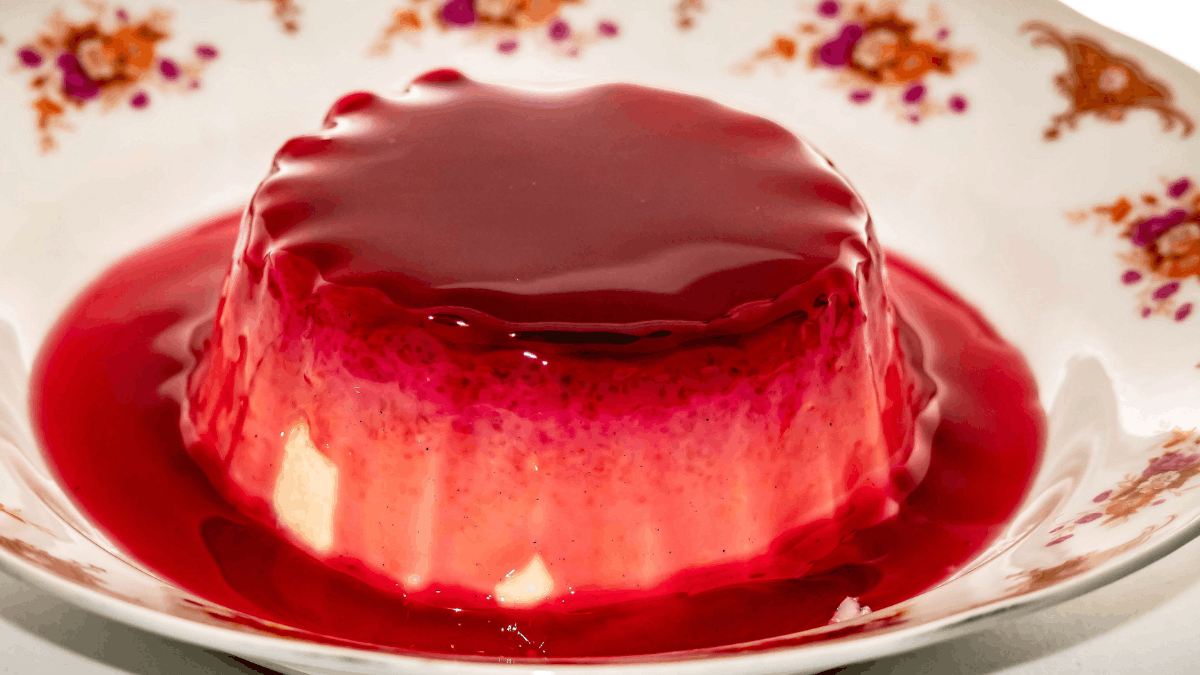 udim de chia saudável com textura cremosa servido em prato branco com calda vermelha natural por cima.