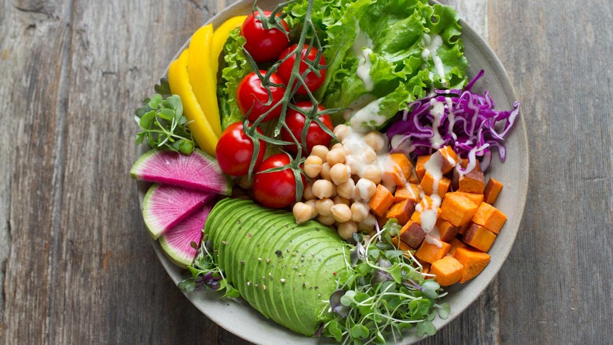 Alimentação anti-inflamatória para reduzir gordura abdominal Prato colorido com legumes e proteínas vista de cima representando alimentação saudável anti-inflamatória
