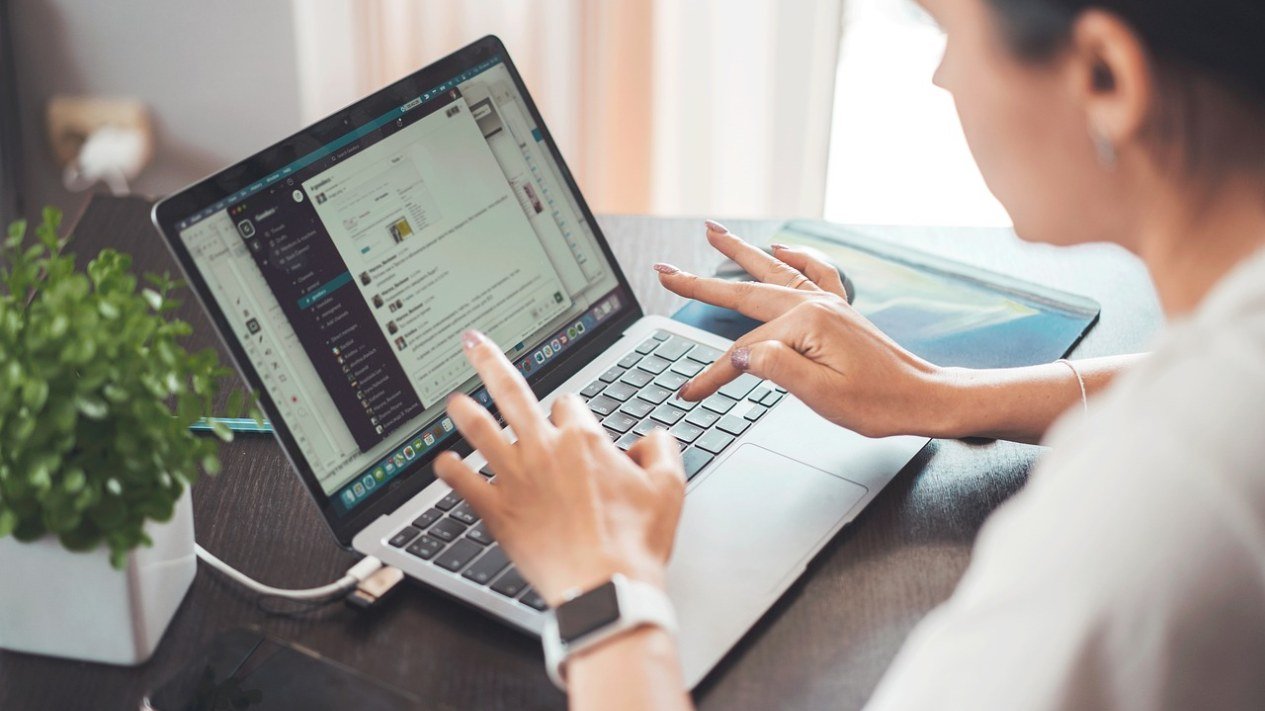 Mulher digitando em um notebook sobre a mesa de casa, simbolizando a compra de remédios pela internet
