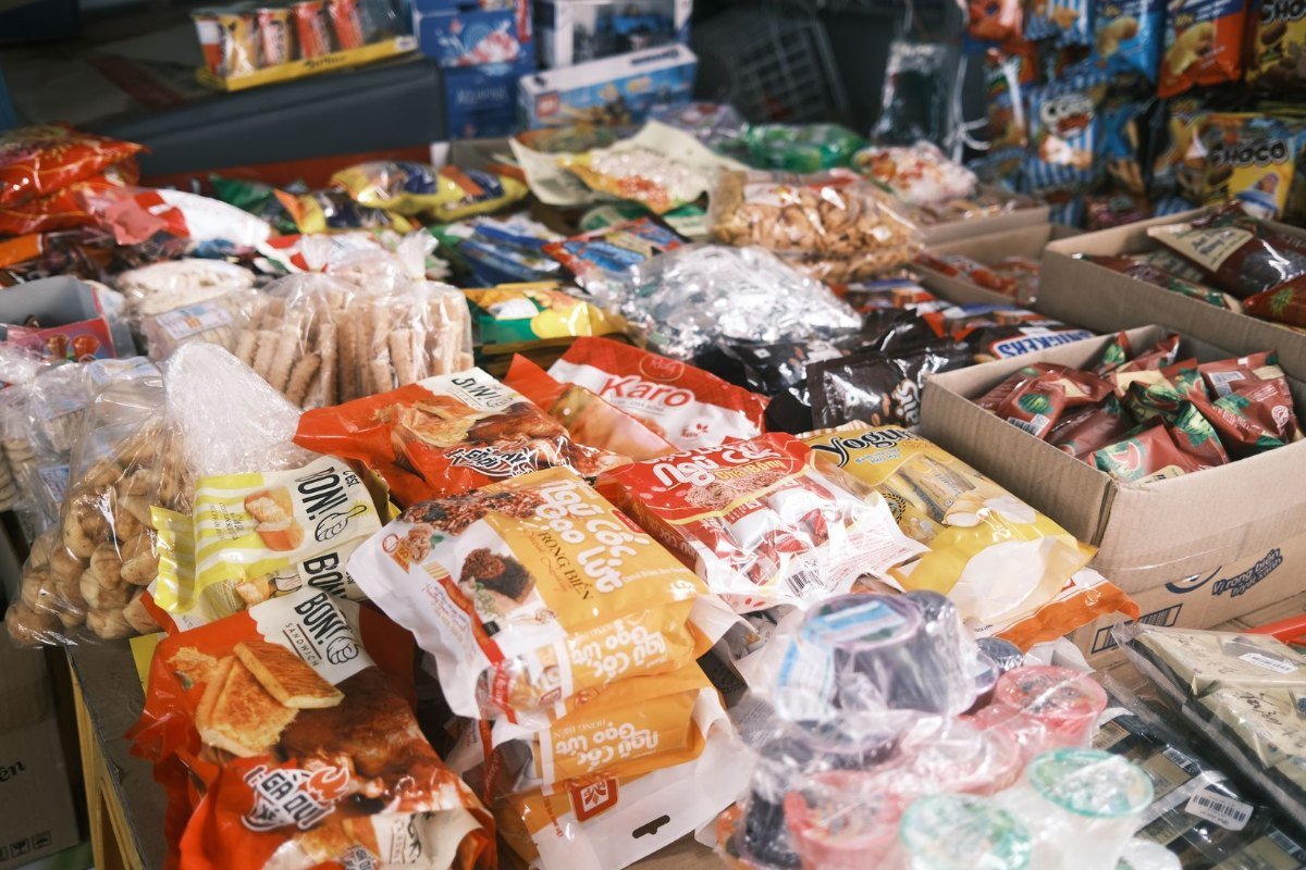 Seleção de doces e salgadinhos embalados em uma banca, exemplos comuns de alimentos ultraprocessados