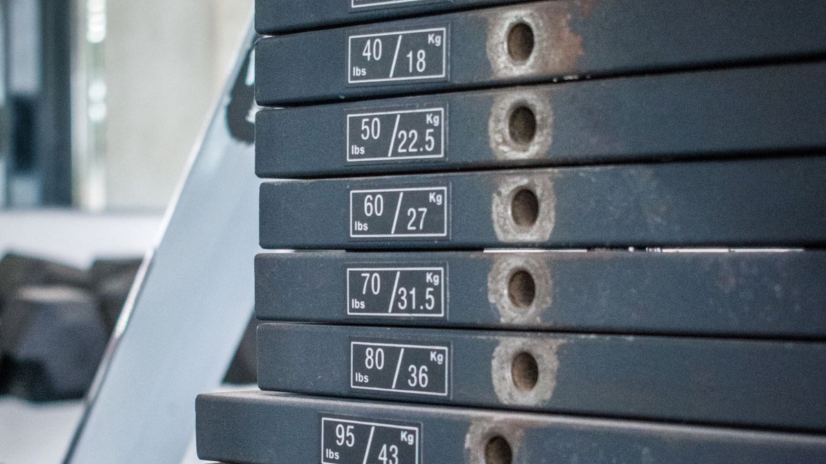 Pilha de pesos de um aparelho de musculação em uma academia, vista de perto