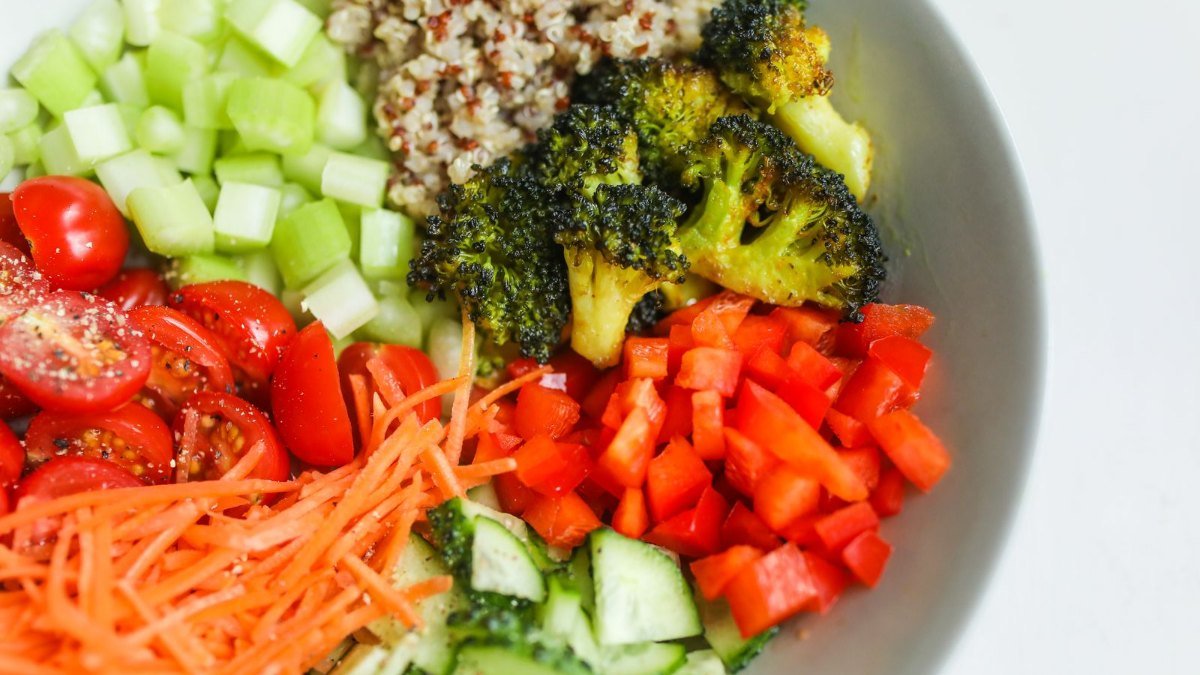 Tigela de salada com brócolis, quinoa, cenoura e tomate, exemplo de refeição para quem cuida da resistência à insulina